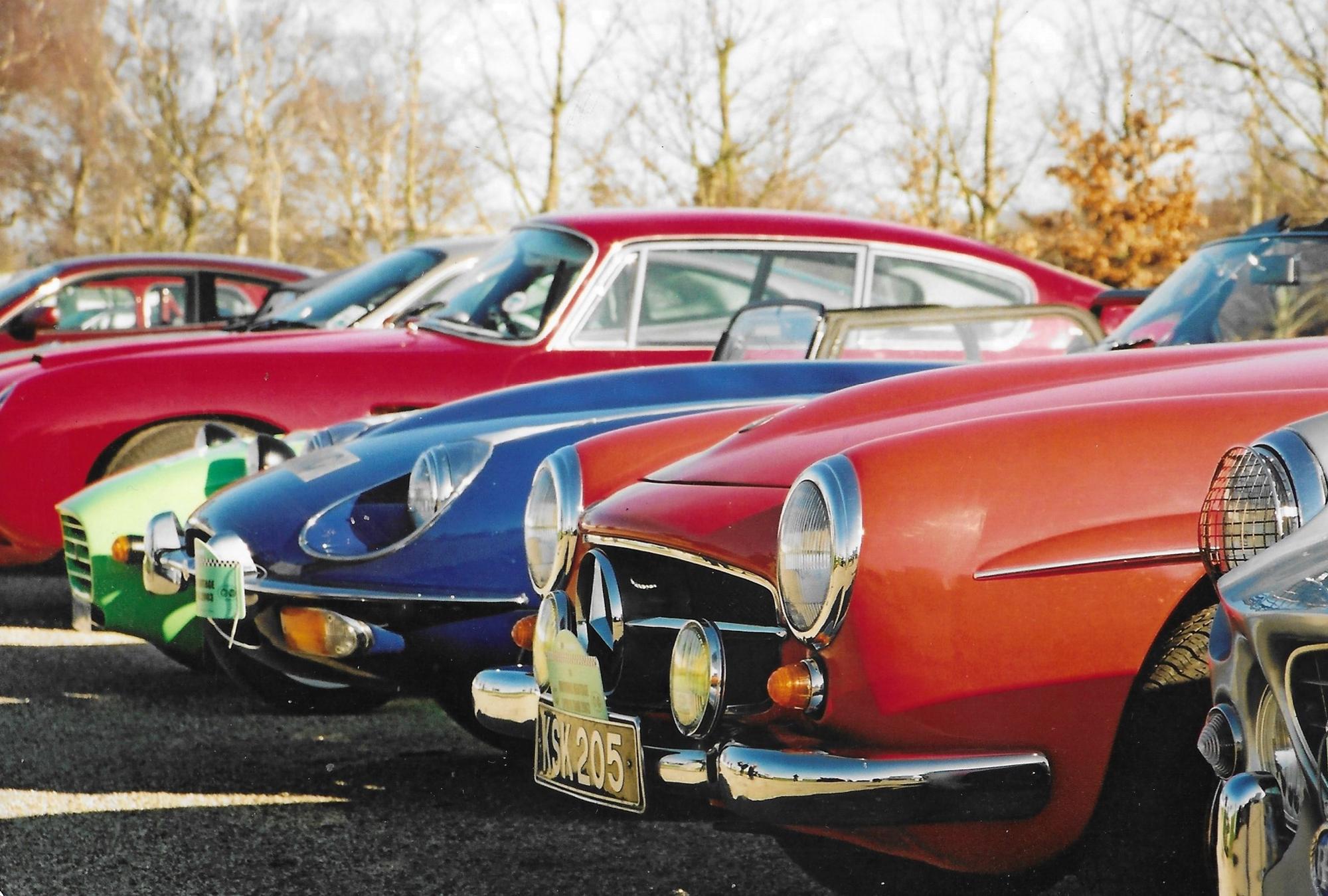 Classic sports cars lined up nose to nose in low winter sun