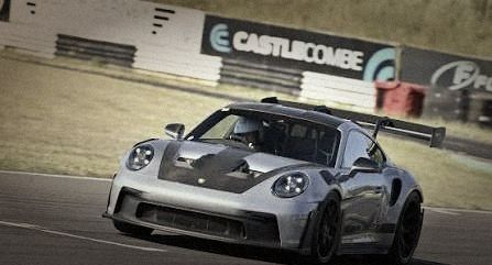A silver Porsche 911 GT3 RS on track at Castle Combe
